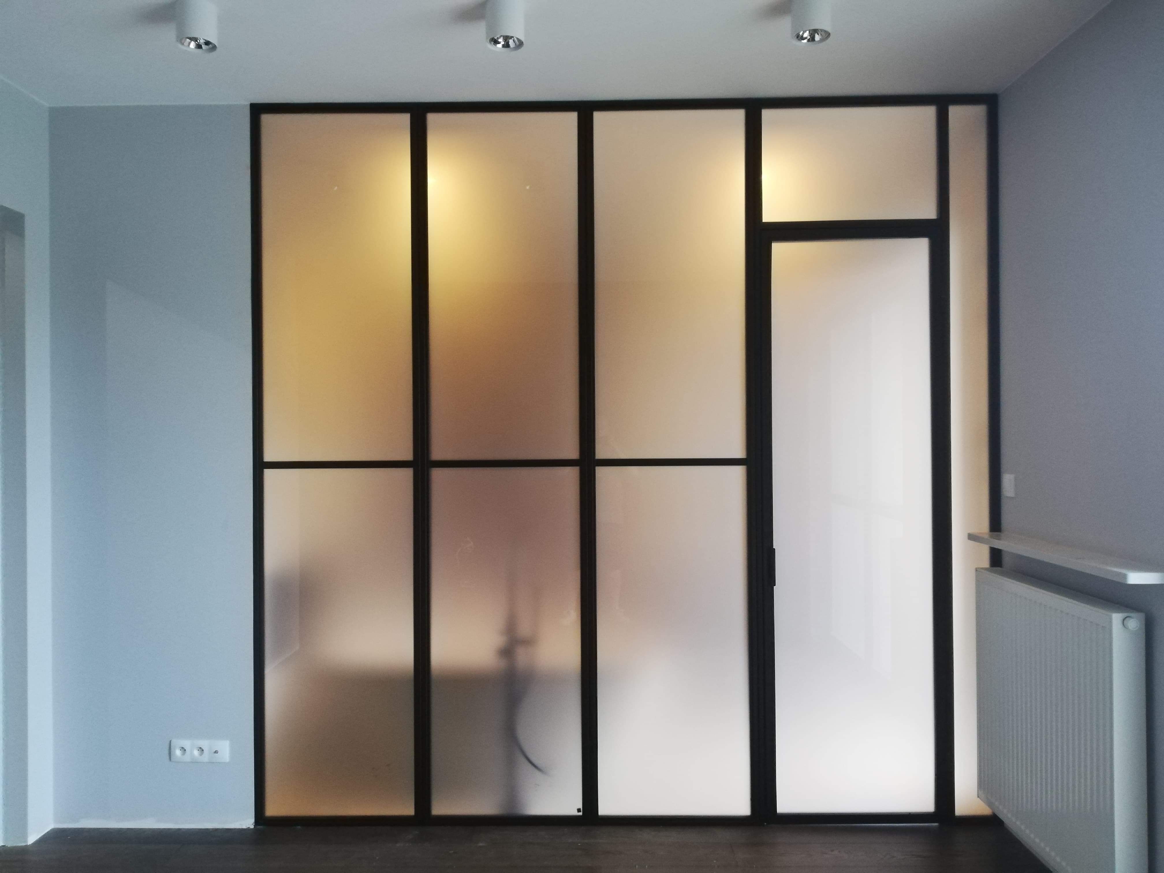 Ściana ze szkłem szybami mlecznymi awowymi w metalowych ramach stylu loftowym industrialnym loft Filip Ch. | Warszawa